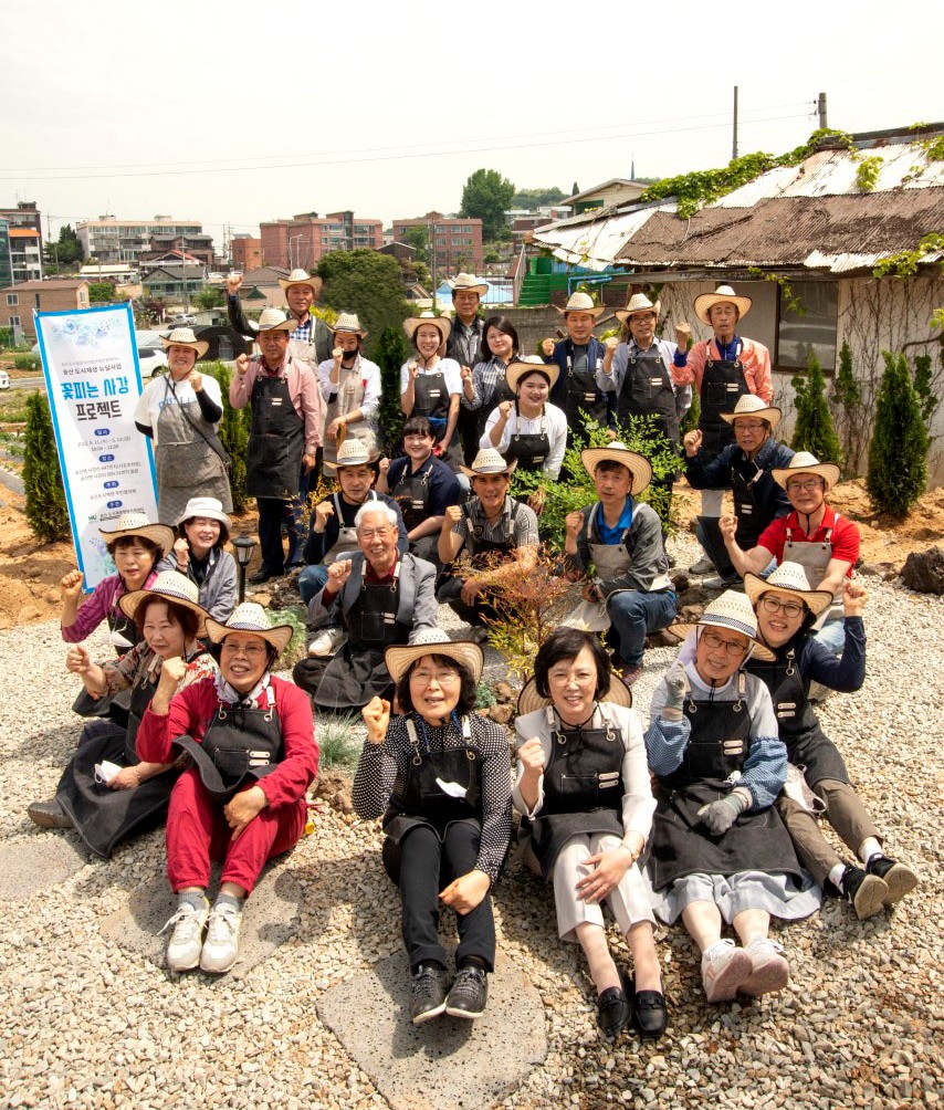 송산지역에서 실시한 꽃피는 사강 2호 프로젝트 성료 후 단체사진 찍는 지역 주민들